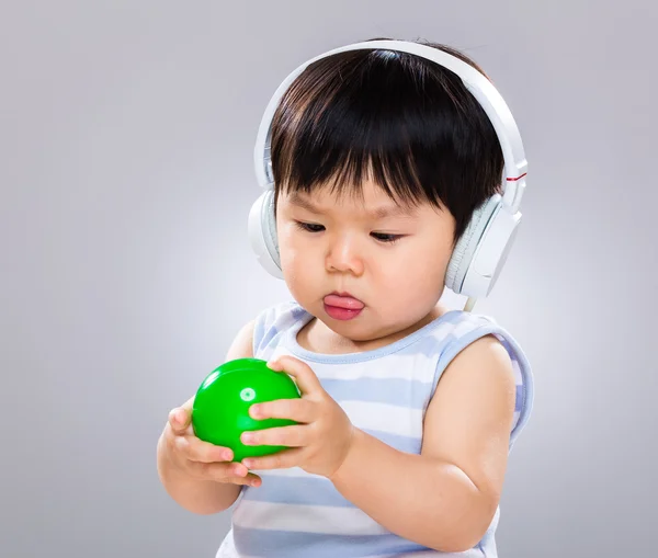 Pojke med hörlurar och spela med plast boll — Stockfoto