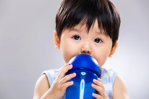 Lille gutt drikke med vannflaske i nærheten – stockfoto