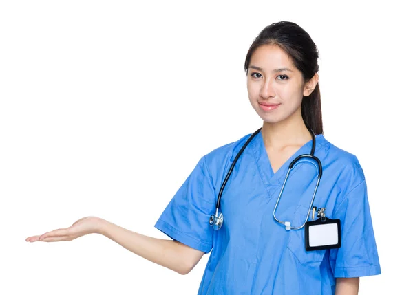 Médica dedicada feminina com mão mostrar algo — Fotografia de Stock