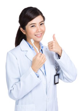 Diş Bakımı kavramı, başparmak ile doktor tutun diş fırçası