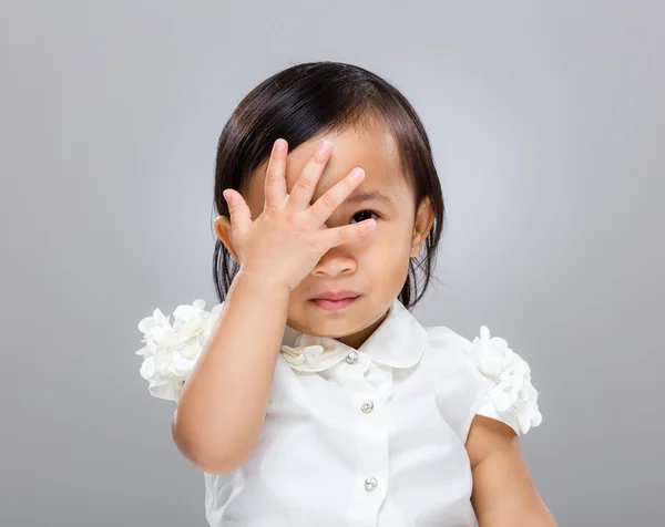 Bebé niña con la mano cubrir su cara — Foto de Stock