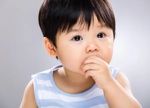 Bebê menino comer biscoito perto — Fotografia de Stock