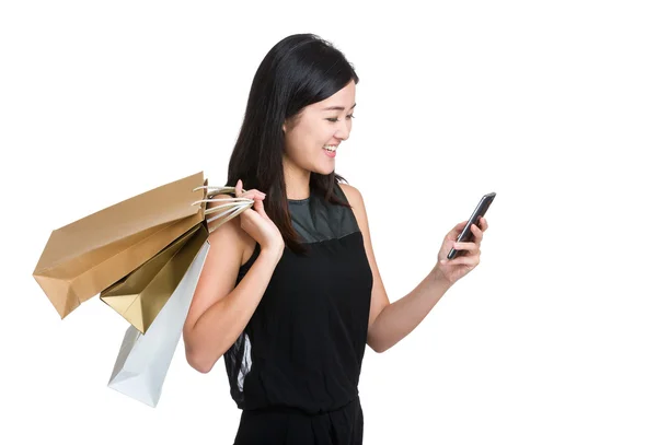 Mulher segurar telefone com saco de compras — Fotografia de Stock