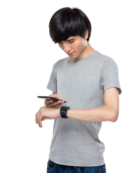 Synchronisation des données du smartphone et de la smartwatch dans la main masculine — Photo