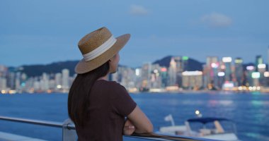 Kadınlar gün batımında Hong Kong manzarasının tadını çıkarırlar.