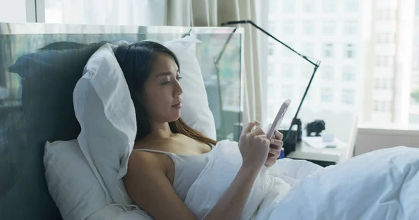 Женщина Лежит Кровати Пользуется Мобильным Телефоном — стоковое фото