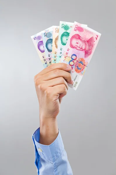 Mão de empresário segura nota chinesa diferente — Fotografia de Stock