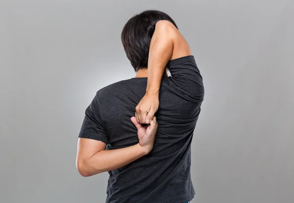 Hombre estirando el brazo detrás de la espalda — Foto de Stock
