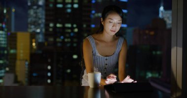 Kadın akşamları tablet bilgisayarda çalışıyor.