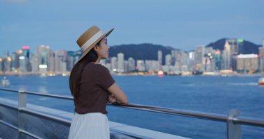 Kadınlar gün batımında Hong Kong manzarasının tadını çıkarırlar.