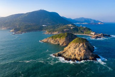 Okyanus dalgaları adada kayalara çarpıyor.