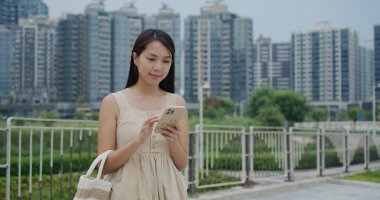 Kadın şehirde cep telefonu kullanıyor