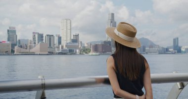 Kadın, Hong Kong manzarasının tadını çıkar.