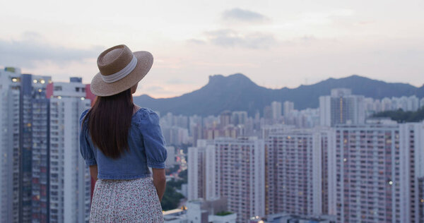 Woman look at the city of Hong Kong at sunset