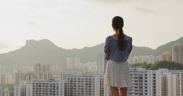 Woman look at the city of Hong Kong in the evening
