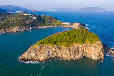 Okyanus dalgaları adada kayalara çarpıyor.