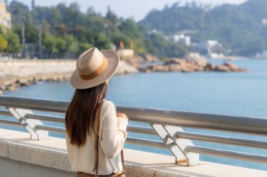 Kadın turist denize bakar ve manzaranın tadını çıkarır.