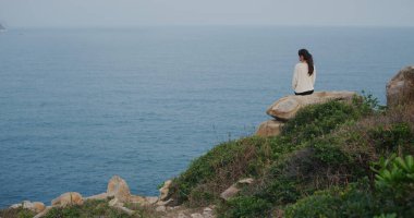 Kadın dağın tepesinde oturur