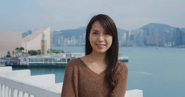 Woman smile to camera with the background of Hong Kong city