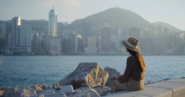 Frau Sitzt Meer Und Blickt Auf Die Stadt Hongkong — Stockfoto
