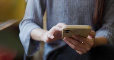 Kadın kahvecide akıllı telefon kullanıyor.