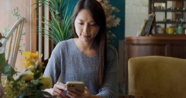 Kadın, kahvecideki cep telefonuna bak.