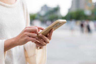 Kadın şehirde cep telefonu kullanıyor.