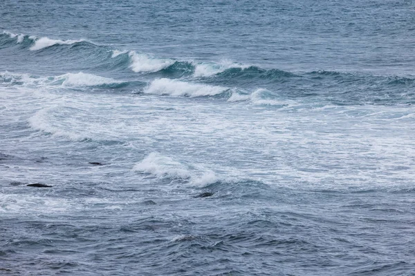 岩のビーチの上に海の波のスプラッシュ — ストック写真