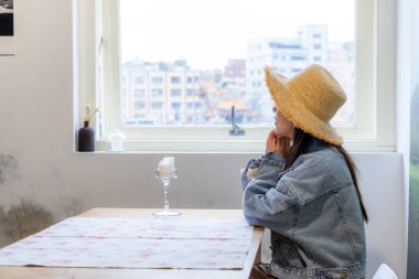 Woman look outside the view and sit inside the restaurant