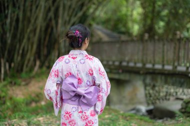 Japon kadın açık hava parkında yukata giyiyor.