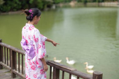 Japon kadın açık hava parkında yukata giyiyor.