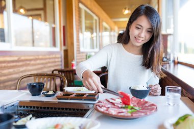 Kadın Japon restoranında yakiniku 'sunun tadını çıkarıyor.