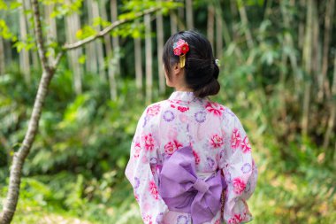 Japon kadın açık hava parkında yukata giyiyor.