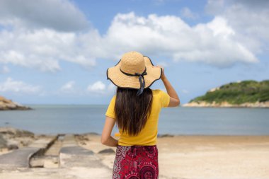 Kadın kumsala gidiyor.