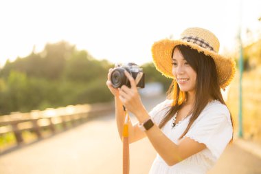 Travel woman use camera to take photo under sunset