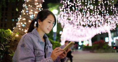 Geceleri kadın cep telefonu kullanıyor.