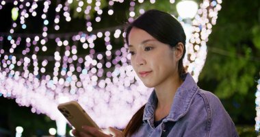 Kadın geceleri şehir içinde hareket eden telefon bakmak