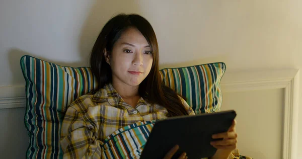 Woman watch on tablet computer on bed at night