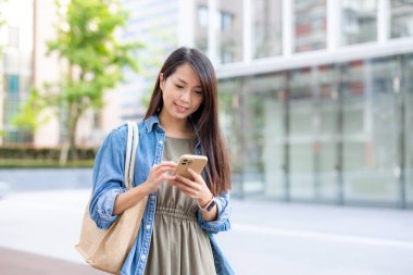 Kadın şehirde cep telefonu kullanıyor