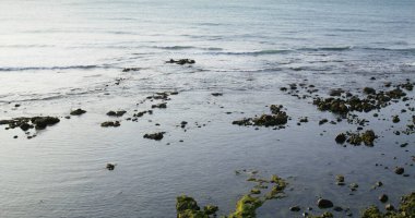 Sea wave splash over the rock at sunset time