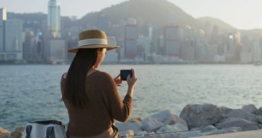 Travel woman use cellphone to take photo in Hong Kong city