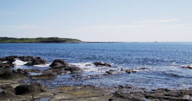 Stone rock sea beach with sunny sky