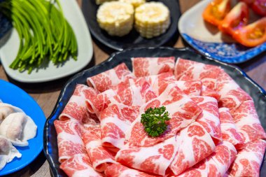 Sliced of beef and food on table in restaurant