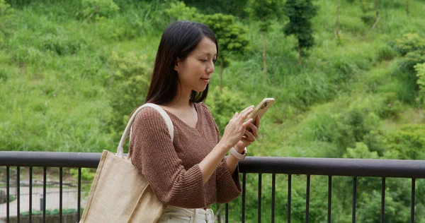 女性は公園で携帯電話を使う — ストック写真