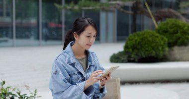 Woman send message on cellphone in the street