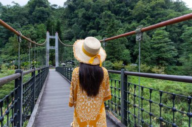 Travel woman walk in the wooden suspension bridge