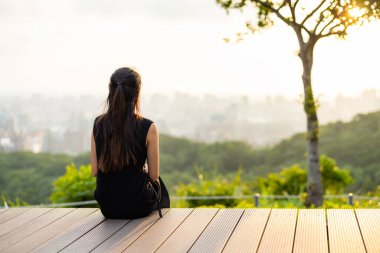 Kadın otur ve gün batımını izle.