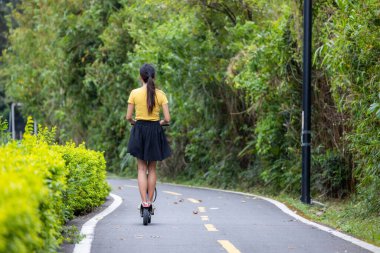 Parkta motorsikletle oynayan bir kadın