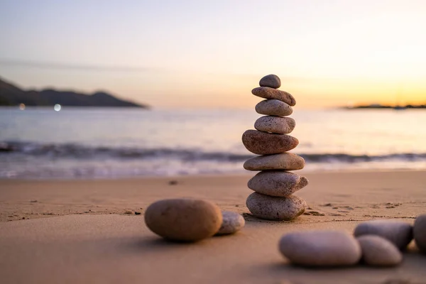 Stones balance on beach at sunset