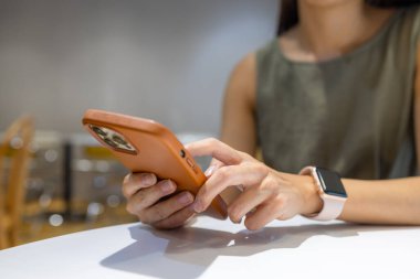 Kadınlar kafede yemek sipariş etmek için cep telefonu kullanırlar.